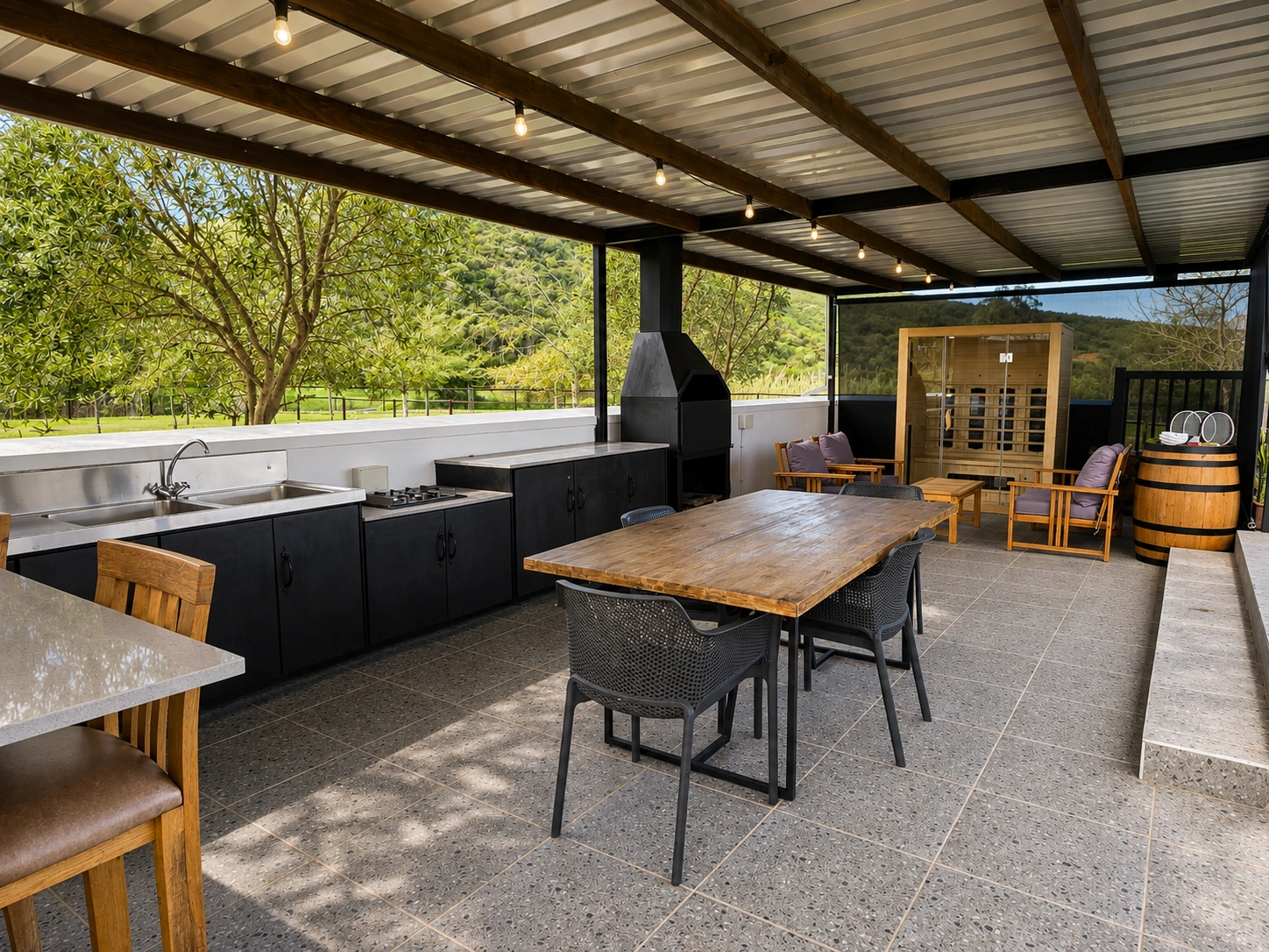 Covered Strings outdoor living area with dining table, lounge, sauna, preparation kitchen and braai